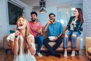 Group of friends playing karaoke at home. Concept about friendship, home entertainment and people