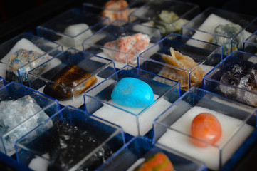 collection of minerals and precious stones in glass boxes. turquoise mineral in focus