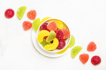 Multicolored marmalade in sugar, light background, top view