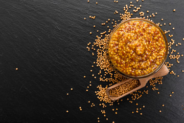 mustard in a bowl on a rustic background