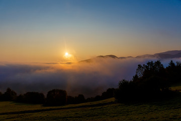 Naklejka na ściany i meble A beautiful morning landscape with sunshine and fog.