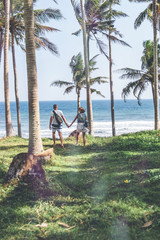 Young couple among palms on the tropical island of Bali.