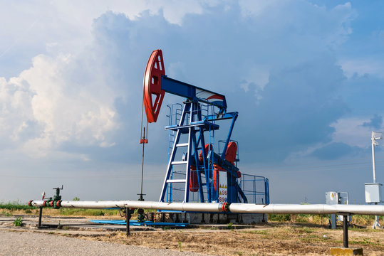 Working oil rig in a cornfield