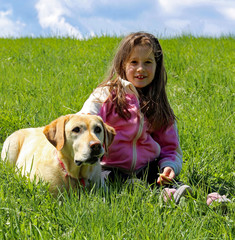 smiling little girl on the lawn with the watchdog