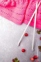 Pink scarf near knitting needles