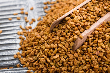 fragrant grains of fenugreek on a rustic background