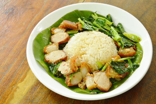 stir fried Chinese kale with crispy pork and rice on plate
