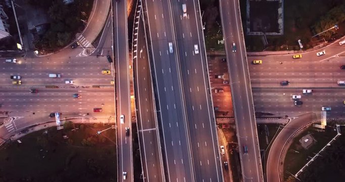 4K. Aerial view of highway road interchange with busy urban traffic speeding on the road at night. Crossing bridges of transportation in Bangkok, Thailand. taken by drone