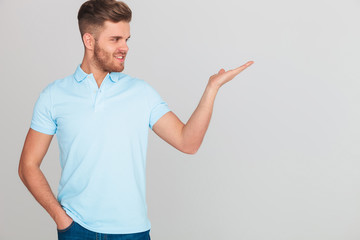 relaxed casual man in light blue polo t-shirt presenting side