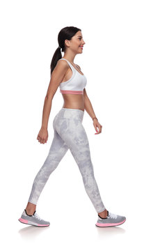 side view of smiling fitness woman walking