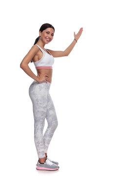 side view of fitness smiling woman presenting to side