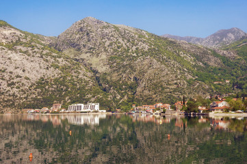 Fototapeta premium Coastal mountains are reflected in water. Montenegro, Bay of Kotor ( Adriatic Sea ), Risan town