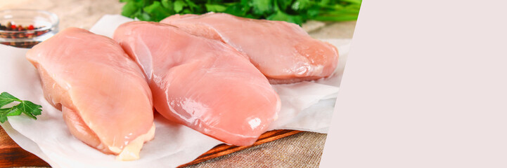 raw chicken fillets on wooden cutting board.