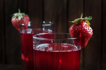 Strawberry juice on dark wooden background