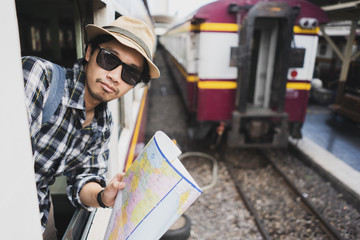 Asian man bag pack tourist with map in railway station at Thailand.