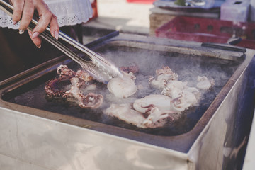 Grilling delicious seafood at street food market