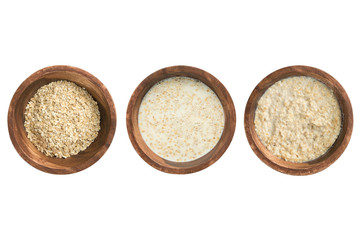 Cooking porridge in wooden plate on white background, isolated