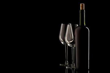 Wine bottle with cork and empty glass on black isolated background