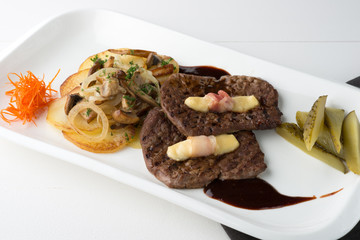 Grilled meat steaks with vegetables, pickles, sauce and decoration on white background