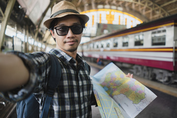 Asian man bag pack tourist take a selfie in railway station at Thailand.