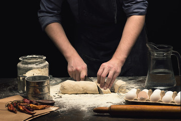 Chef hands are preparing pizza dough on wooden table