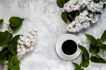Cup of coffee serving with lilac and leaves