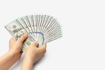 Female hands are holding a fan of new 100 dollar banknotes on white background