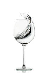 Clear water splashing in the wine glass. vertical isolated