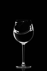 A wine glass with splashing of water on black background