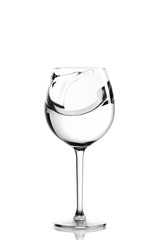 Clear water splashing in the wine glass. vertical isolated