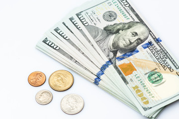 Fototapeta premium A fan of 100 dollar bills with coins on white background