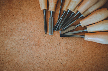 Tools for woodcarving on brown rough background top view