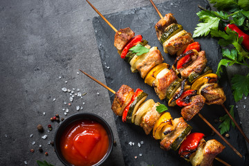 Grilled shish kebab with vegetables  on black.