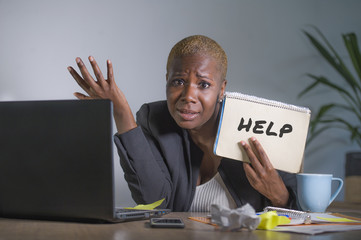 sad and depressed black afro American woman suffering stressed at office working with laptop computer feeling overwhelmed asking for help