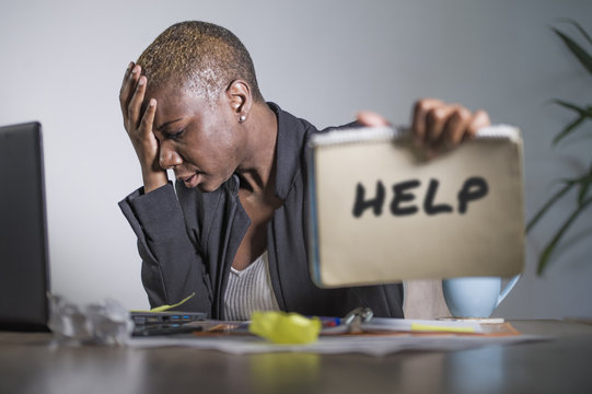 sad and depressed black afro American woman suffering stressed at office working with laptop computer feeling overwhelmed asking for help