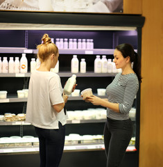 Two women choosing a dairy products at supermarket