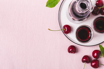 Cherry alcohol drink liquor or brandy on pink background