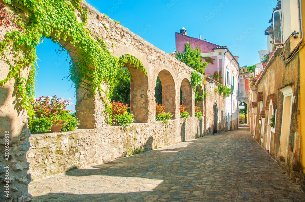 Wall mural old european street with stone wall