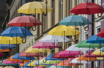 Fototapeta na wymiar colorful umbrellas hang on the background of the old city in the lviv