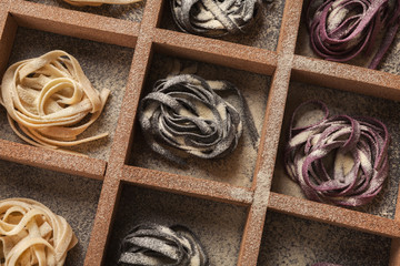 Colorful tagliatelli nests on black background