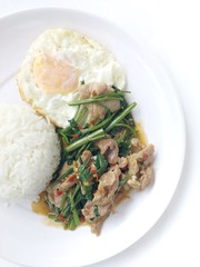 Stir fried morning glory (Pad Pak Boong) with pork and thai fried egg on top of hot rice in white dish on white background. Thai food is very delicious.