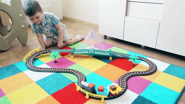 The boy watching the train as he passes by rail
