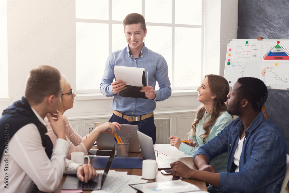 Poster man giving presentation to colleagues in office