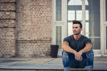 Handsome muscular man with tattoo posing in European city center, Turin, Italy