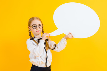 Girl with red pigtails on a yellow background. A charming girl in round transparent glasses is holding a white text box.