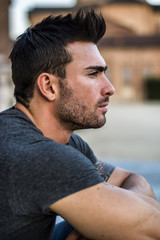 Fototapeta premium Handsome muscular man with tattoo posing in European city center, Turin, Italy