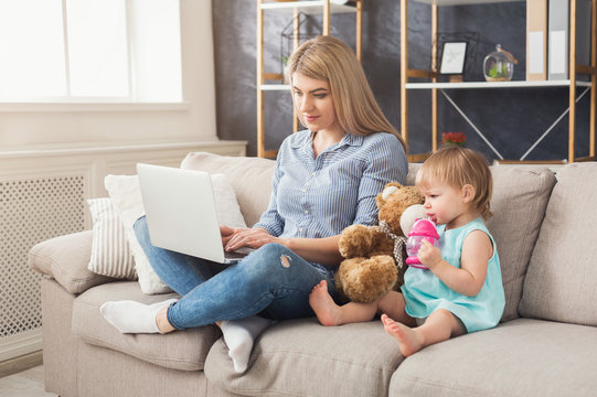 Young mother working and spending time with baby