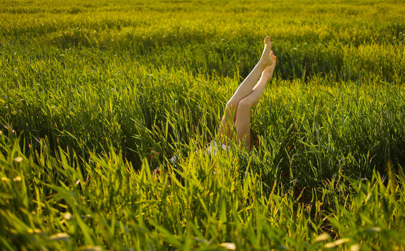 Hello, June! The concept of summer. Girl on the field with green wheat, welcomes the first day of summer