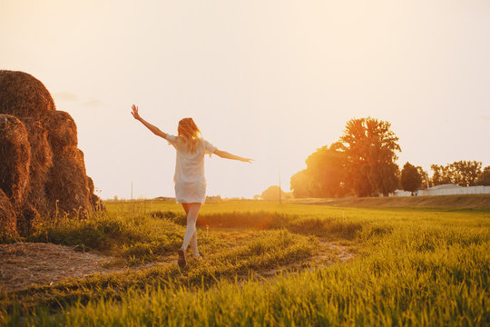 Hello, June! The concept of summer. Girl on the field with green wheat, welcomes the first day of summer