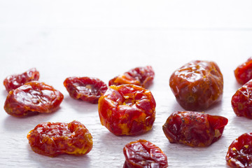 sun dried whole tomatoes on white wood table background